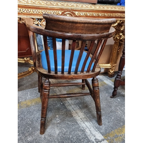 962 - Antique wooden captains chair with spindle back and turned legs, featuring a blue cushioned seat. Oa... 