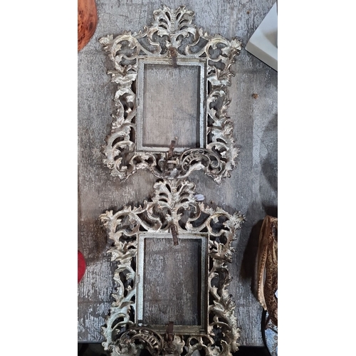 982 - Two ornate, gilded metal picture frames with intricate scrollwork designs, reflecting a classic Baro... 