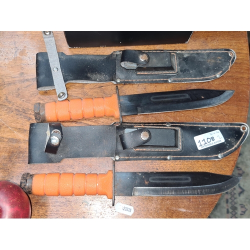 1108 - A pair of matching hunting knives with original sheaths and mini sharpening blocks.