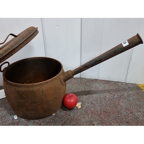 1322 - A large heavy cast iron kettle with long spout and lid. Rustic patina adds character.
Previous in au... 