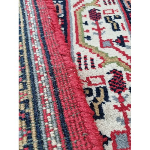 943 - Super Star Lot : A large handmade, hand knotted floor rug dominantly in red featuring a repetitive p... 