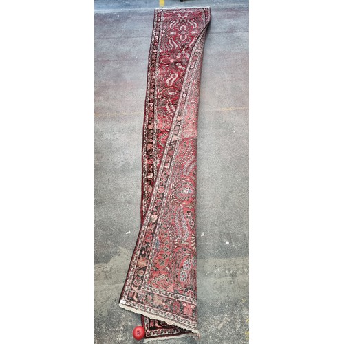 945 - Star Lot : A super hand knotted Persian runner / rug with red ground with floral design in red, beig... 