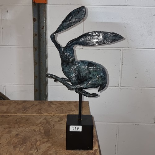 319 - Star Lot: A large Intricate heavy bronze sculpture depicting a whimsical hare in mid-leap, showcasin... 