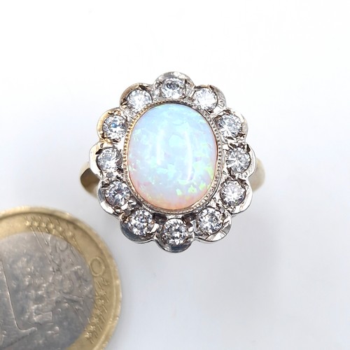 24 - A silver gilt fire opal stone ring with gem set surround. Ring size - Q 1/2. Weight - 5.45 grams.