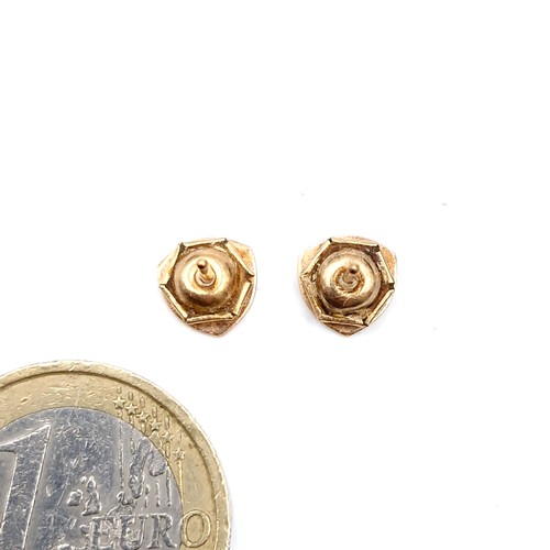 36 - A pair of machine cut nine carat gold stud earrings. Weight - 0.75 grams. Boxed.