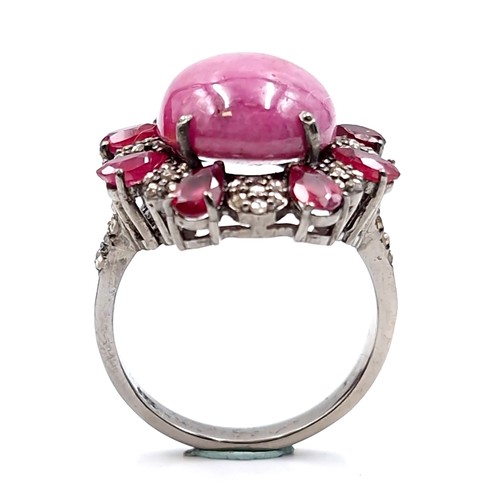 124 - Star Lot : A stunning example of a large Ruby cabochon gemstone ring with diamond and ruby surround ... 