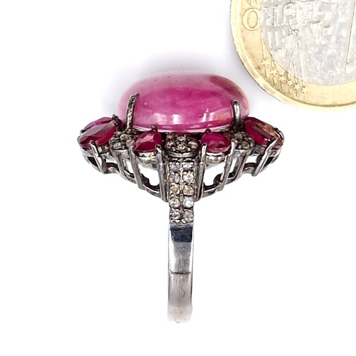 124 - Star Lot : A stunning example of a large Ruby cabochon gemstone ring with diamond and ruby surround ... 