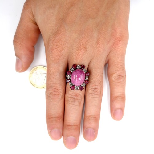 124 - Star Lot : A stunning example of a large Ruby cabochon gemstone ring with diamond and ruby surround ... 