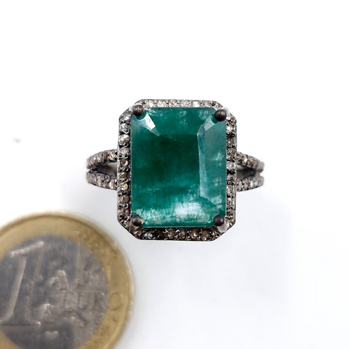 560 - Star lot : A very impressive 7 carat emerald ring with .85 carat diamond surround and shoulders set ... 