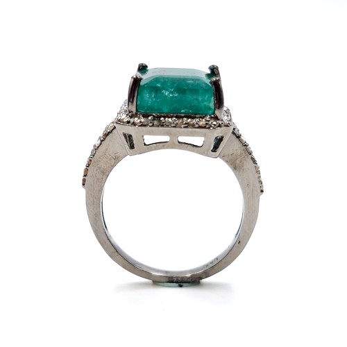 560 - Star lot : A very impressive 7 carat emerald ring with .85 carat diamond surround and shoulders set ... 