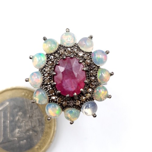 561 - Star Lot : A very attractive 3.7ct ruby set ring with .20ct diamond and 2.90cts opal surround mounte... 