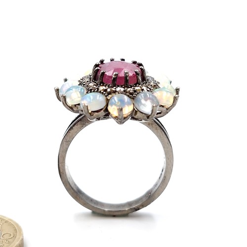 561 - Star Lot : A very attractive 3.7ct ruby set ring with .20ct diamond and 2.90cts opal surround mounte... 