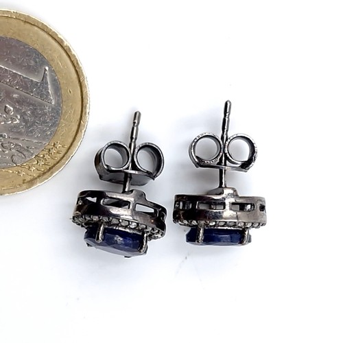 591 - Star Lot : A pair of 4ct oval cut blue sapphire stud earrings with diamond halo set in sterling silv... 