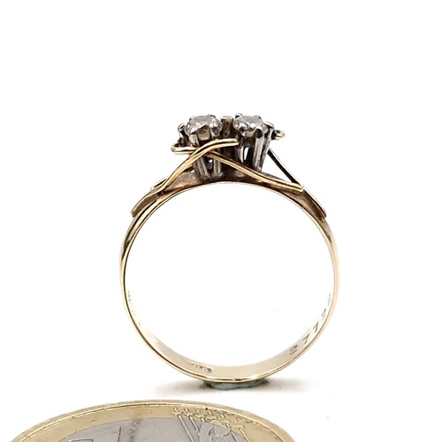 1053 - Star Lot : A nine carat gold (375) two stone diamond ring set with swirl mount. Est. weight of diamo... 