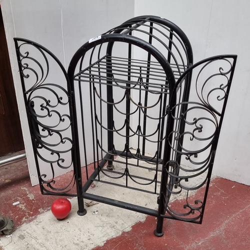 364 - Black wrought iron wine rack with ornate scrollwork, featuring a curved top and double doors.