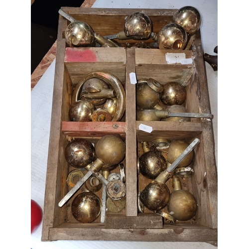 373 - Collection of vintage brass door knobs and fixtures in a vintage wooden box with dividers.