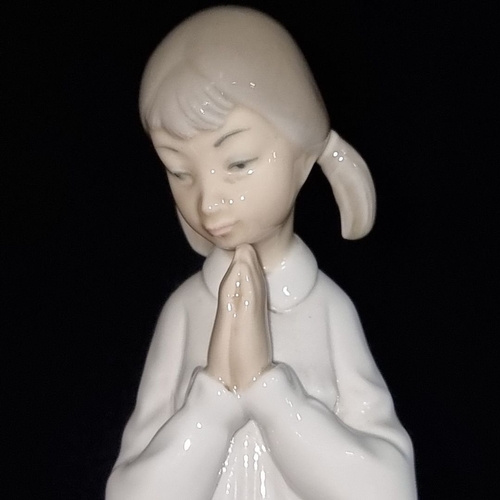 399 - Three Spanish porcelain figurines depict three praying children. Including LLadro.