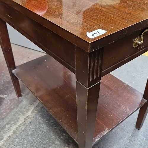 417 - Wooden side table with brass handles, featuring a single drawer and lower shelf. Emphasizes practica... 