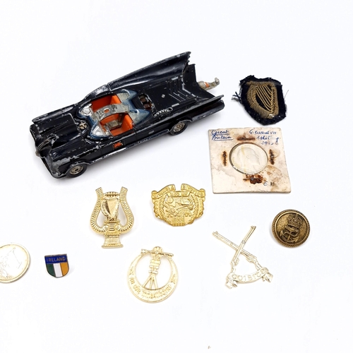 512 - A collection of items consisting of badges, and Edwardian silver shilling together with a bat mobile... 