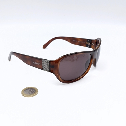 513 - A pair of faux tortoise shell Versace 'Made in Italy' sunglasses.