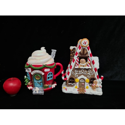 186 - Two characterful Christmas themed decorations including a gingerbread house and a cute cottage in th... 