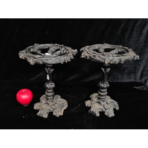 191 - A pair of heavy ornate cast iron trivets with pierced scroll design.