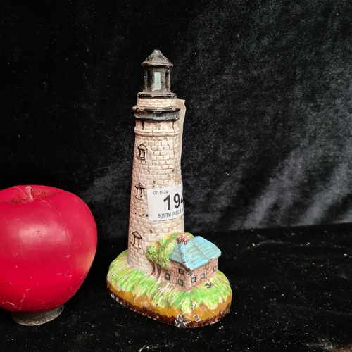 194 - A hand painted heavy cast iron lighthouse moneybox.