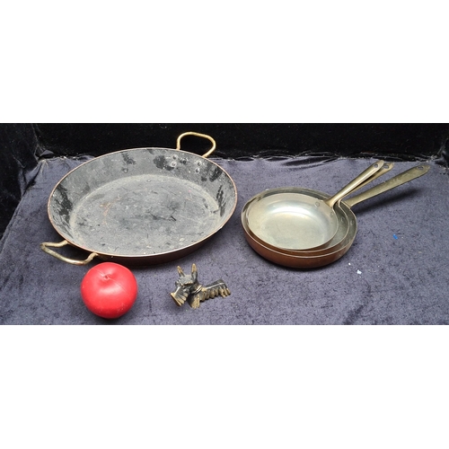 291 - Four vintage copper and brass pans along with a very sweet brass Scottie dog knife / spoon rest.