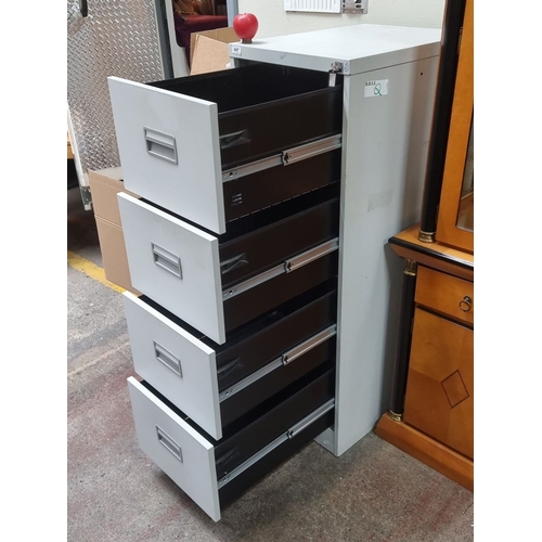 447 - Metal four-drawer filing cabinet with lock and key. Features durable construction and sleek design. ... 