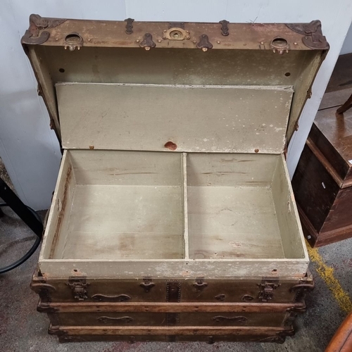 454 - Victorian wooden and metal-bound travel trunk with ornate hardware, featuring a spacious, divided in... 