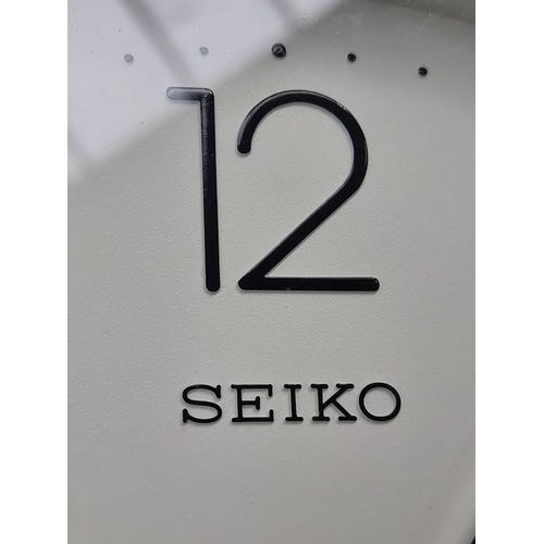 465 - Two wall clocks: one Seiko quartz clock with a minimalist design, and another clock featuring butter... 