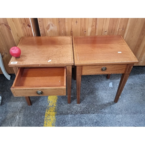 492 - Pair of satin wood  side tables with single drawer and brass handles, featuring simple inlay detail.