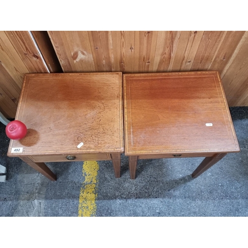 492 - Pair of satin wood  side tables with single drawer and brass handles, featuring simple inlay detail.