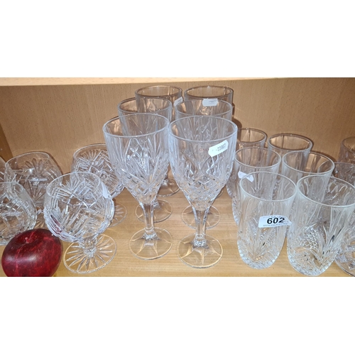 602 - Collection of cut crystal glassware, including wine glasses, cocktail glasses, and tumblers. Feature... 