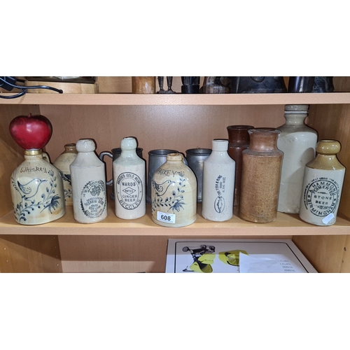 608 - Collection of vintage stoneware bottles, including whiskey and ginger beer varieties, featuring deco... 