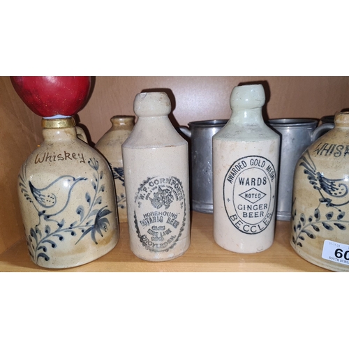 608 - Collection of vintage stoneware bottles, including whiskey and ginger beer varieties, featuring deco... 