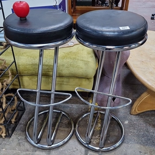 661 - Pair of modern chrome bar stools with black leather seats, featuring sturdy footrests and sleek base... 