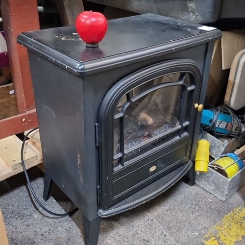 664 - Electric stove heater with faux log design and black metal exterior. Features a clear viewing window... 