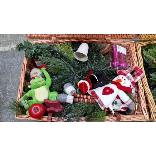 677 - Two wicker baskets of assorted Christmas decorations, including plush toys, artificial greenery, and... 