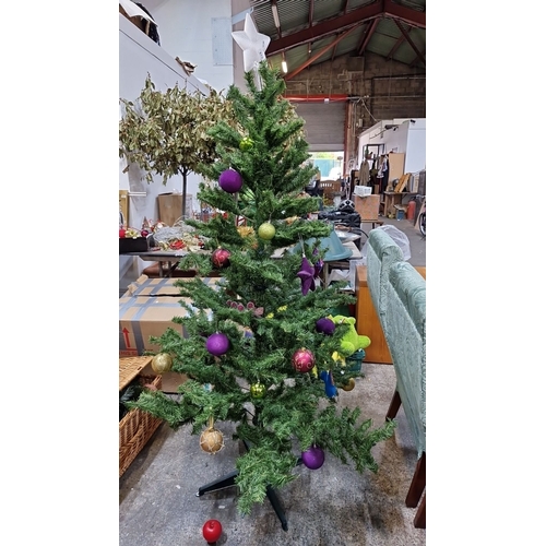 679 - Artificial Christmas tree with assorted colorful ornaments, including purple, green, gold, and red b... 