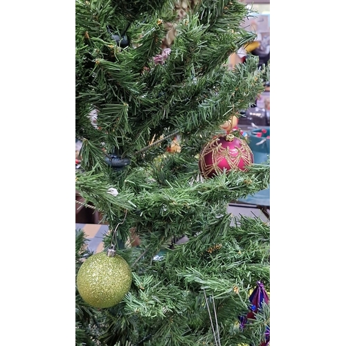 679 - Artificial Christmas tree with assorted colorful ornaments, including purple, green, gold, and red b... 