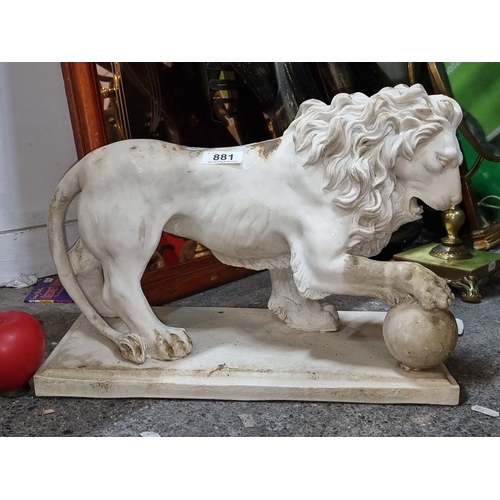 881 - A composite lion sculpture with detailed mane, poised on a rectangular base. Height approximately 12... 