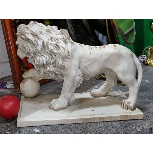 881 - A composite lion sculpture with detailed mane, poised on a rectangular base. Height approximately 12... 