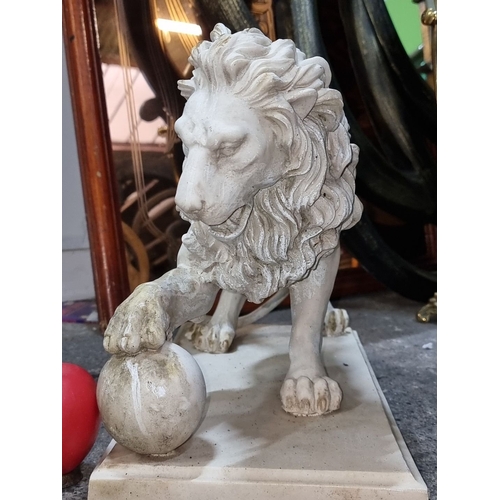 881 - A composite lion sculpture with detailed mane, poised on a rectangular base. Height approximately 12... 