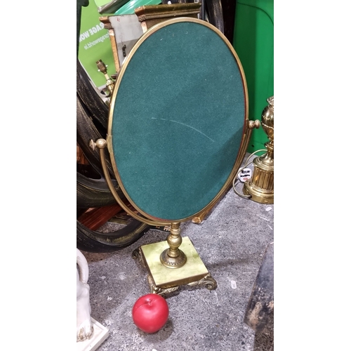 882 - Victorian-style brass vanity mirror with an oval frame and ornate base. Features green felt backing.