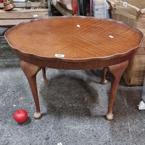 886 - A Vintage wood coffee table with scalloped edge and tapered legs, from mid-20th century. Features an... 