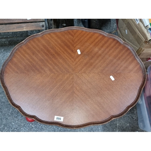 886 - A Vintage wood coffee table with scalloped edge and tapered legs, from mid-20th century. Features an... 