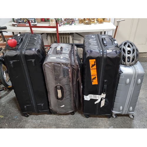 889 - Four unchecked lost luggage set includes two black, one brown, and one silver suitcase. Various size... 