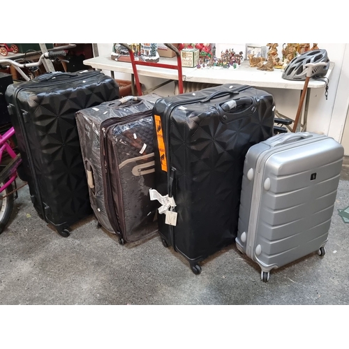 889 - Four unchecked lost luggage set includes two black, one brown, and one silver suitcase. Various size... 