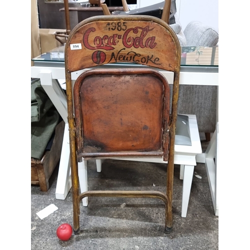 894 - 1985 Coca-Cola folding chair features New Coke branding, a hand-painted design, and a metal frame. I... 